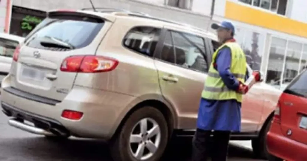 Parking attendant in yellow vest gilet jaune standing near parked cars in Morocco